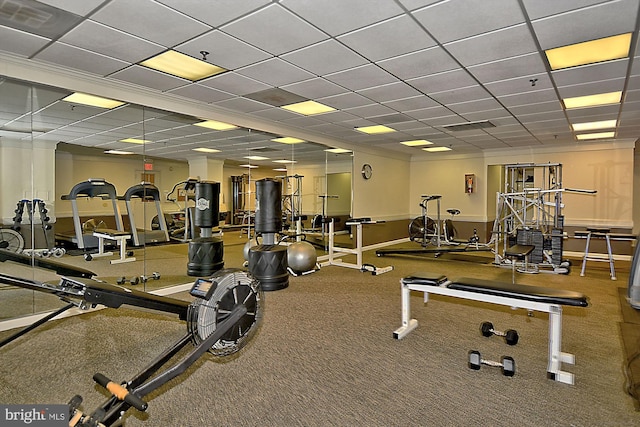 workout area with a paneled ceiling and baseboards