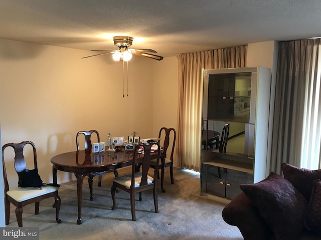 carpeted dining space featuring ceiling fan