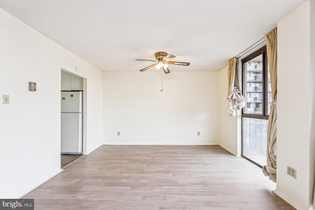 unfurnished room with light wood-type flooring and ceiling fan