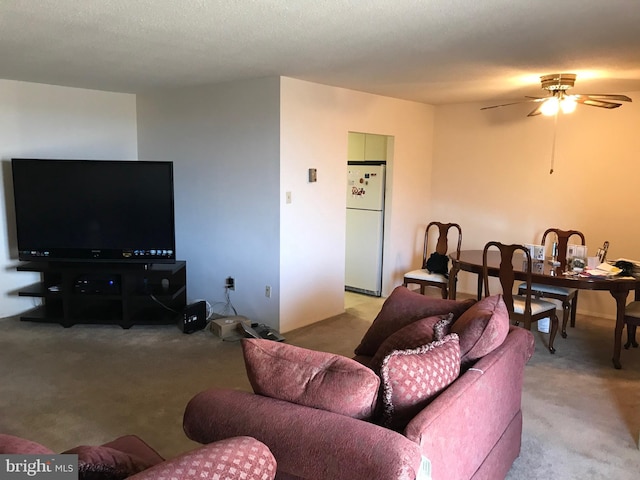 carpeted living room featuring ceiling fan and a textured ceiling