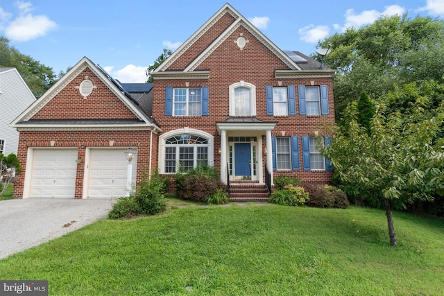 view of front of property with solar panels, a garage, and a front lawn