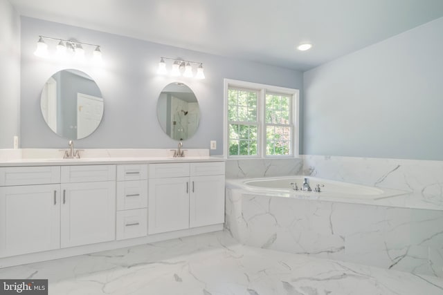 bathroom with tiled tub and vanity