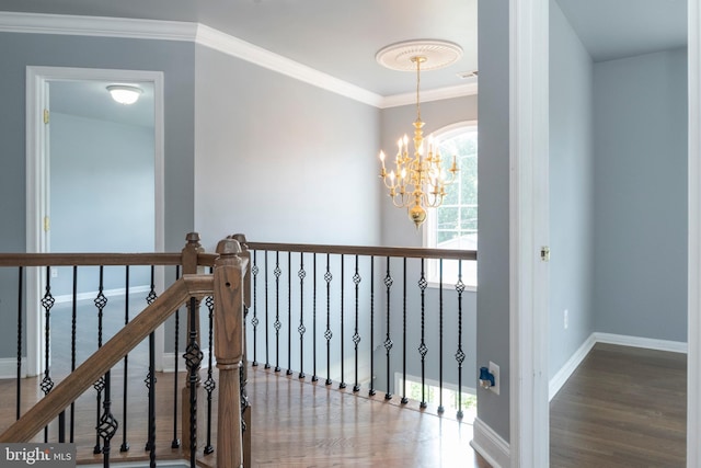 hall featuring ornamental molding, an inviting chandelier, and wood-type flooring