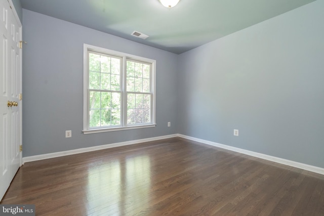 empty room with dark hardwood / wood-style flooring