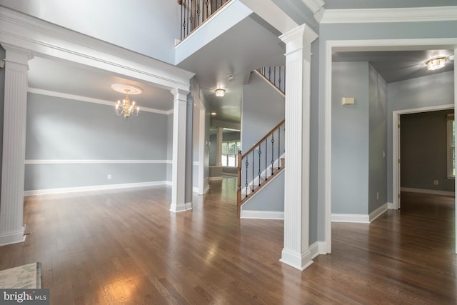 interior space featuring a chandelier, dark wood-type flooring, decorative columns, and ornamental molding