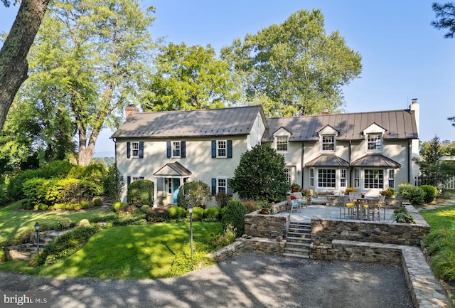 view of front of house featuring a patio and a front lawn