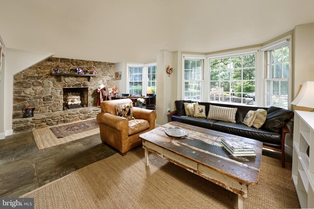 living room featuring plenty of natural light and a stone fireplace