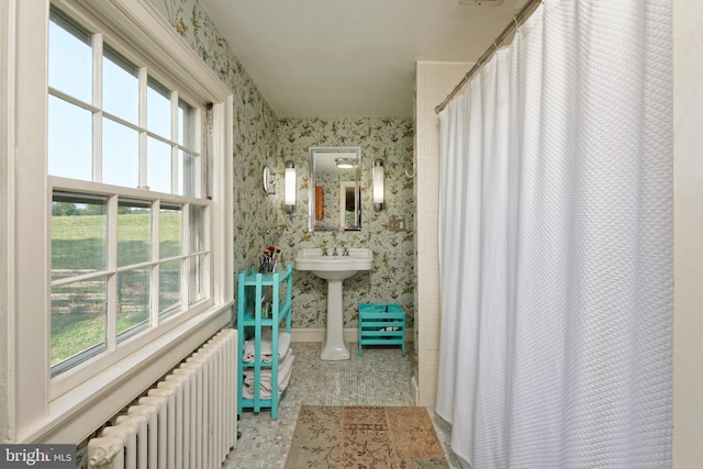 bathroom featuring a shower with shower curtain, radiator heating unit, and tile patterned floors