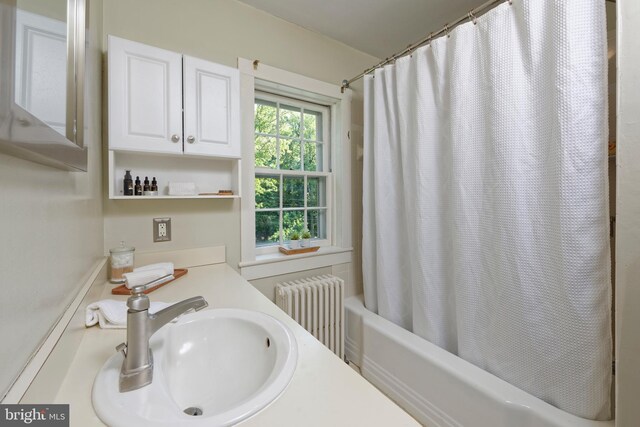 bathroom with sink, radiator heating unit, and shower / bath combo