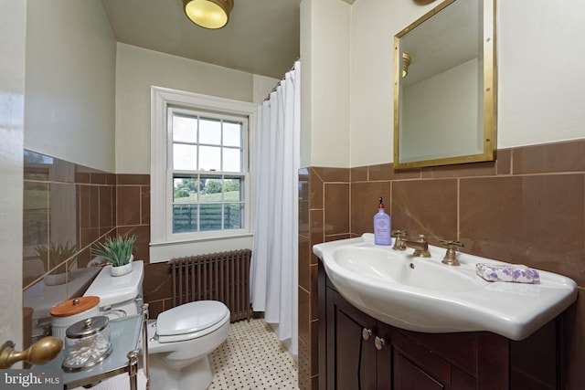 bathroom featuring backsplash, toilet, tile walls, radiator, and vanity