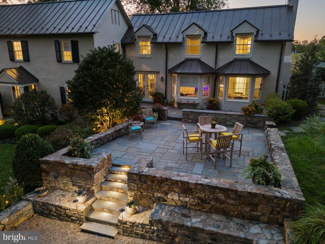 back house at dusk with a patio area