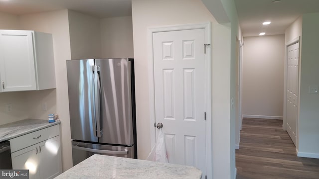 kitchen featuring stainless steel fridge, dark hardwood / wood-style flooring, and white cabinetry