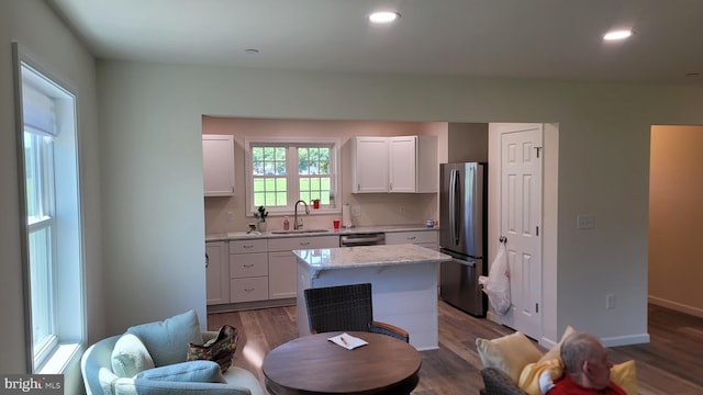 kitchen with white cabinets, a kitchen island, sink, and appliances with stainless steel finishes