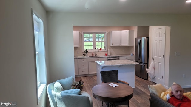 kitchen with a kitchen island, white cabinetry, sink, and appliances with stainless steel finishes