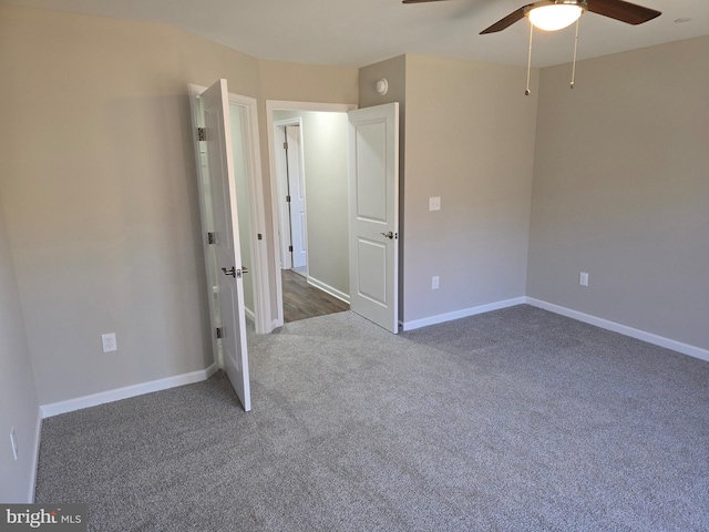 unfurnished bedroom featuring dark carpet and ceiling fan