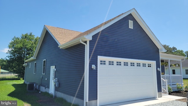 view of side of property featuring central AC unit and a garage