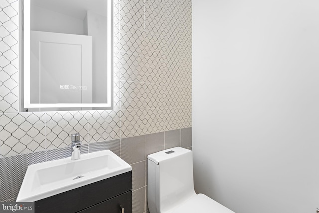 bathroom with tile walls, vanity, and toilet