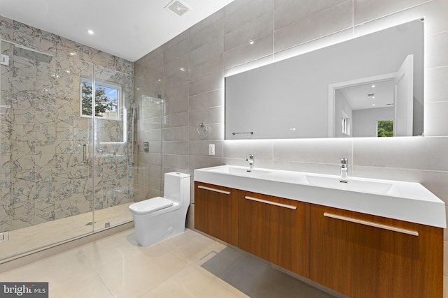 bathroom with tile patterned floors, toilet, tile walls, vanity, and walk in shower