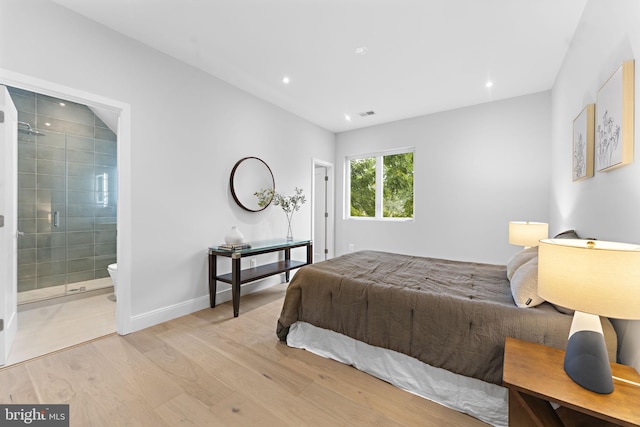 bedroom featuring light hardwood / wood-style flooring and ensuite bathroom