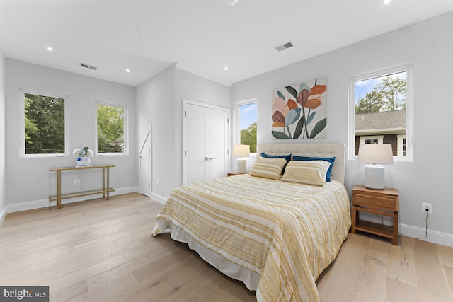 bedroom with multiple windows and light wood-type flooring