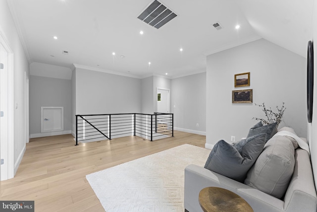 sitting room featuring ornamental molding, light wood-type flooring, and vaulted ceiling