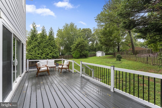 wooden terrace with an outdoor hangout area, a storage unit, and a yard