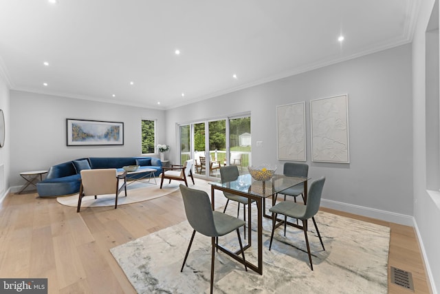 dining area featuring crown molding and light wood-type flooring