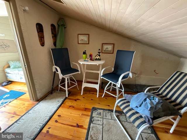 sitting room with lofted ceiling, wooden ceiling, and wood finished floors