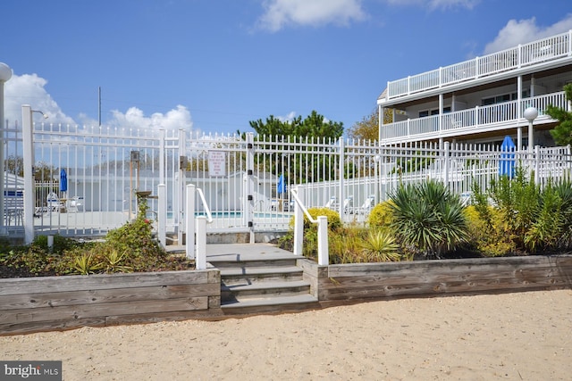 view of property's community featuring a swimming pool and fence