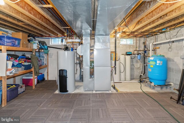 basement with plenty of natural light, heating unit, and water heater