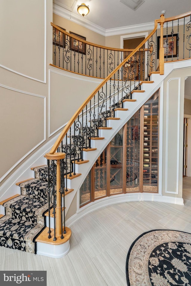 stairs with ornamental molding and tile patterned flooring