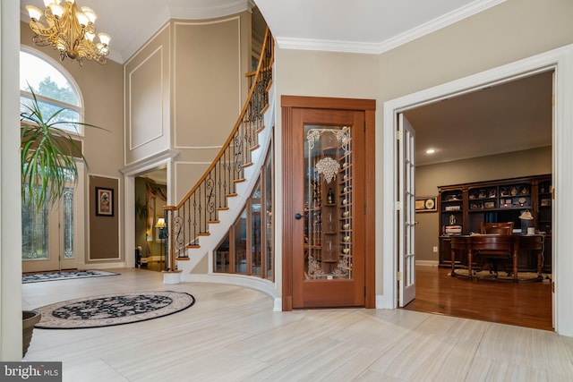 foyer entrance featuring hardwood / wood-style flooring, a chandelier, and ornamental molding