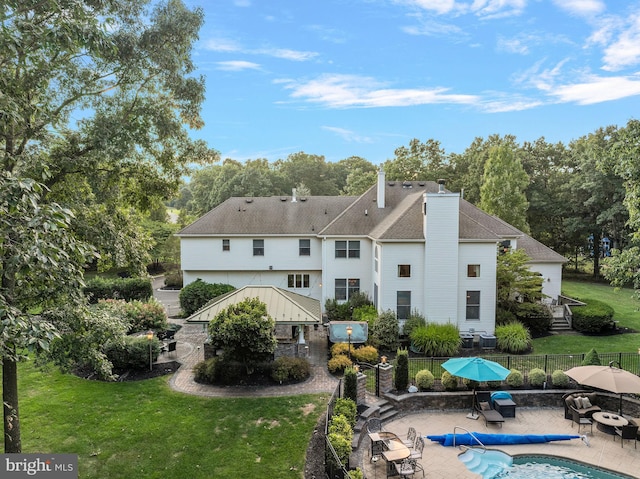 back of house featuring a covered pool, a patio area, and a yard