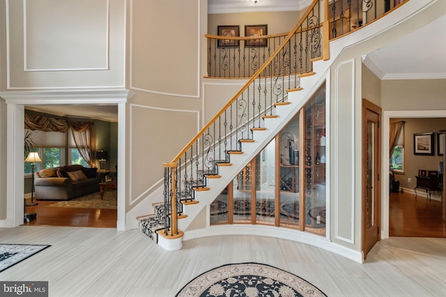 staircase with crown molding and wood-type flooring