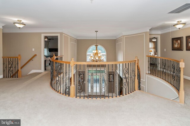 hallway with carpet floors, an inviting chandelier, and ornamental molding