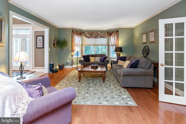 living room with crown molding, hardwood / wood-style flooring, and french doors