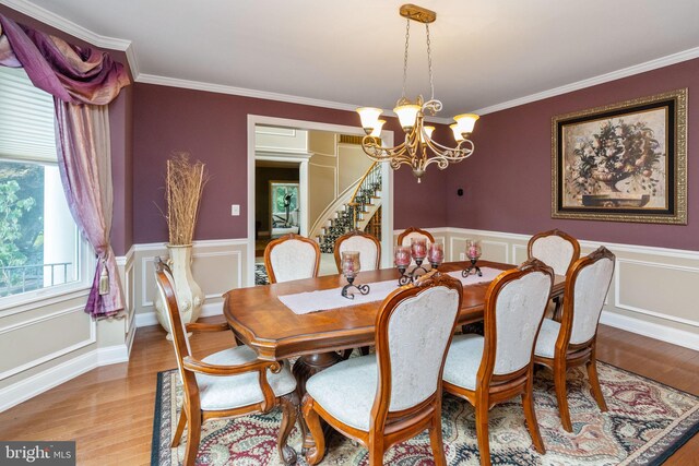 dining area featuring hardwood / wood-style flooring, a notable chandelier, and crown molding