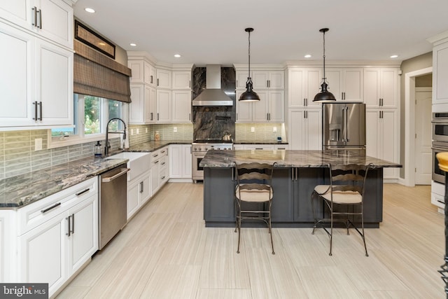 kitchen featuring wall chimney range hood, backsplash, pendant lighting, a center island, and premium appliances