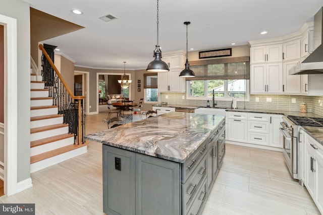 kitchen with gray cabinetry, stainless steel appliances, white cabinetry, and a center island