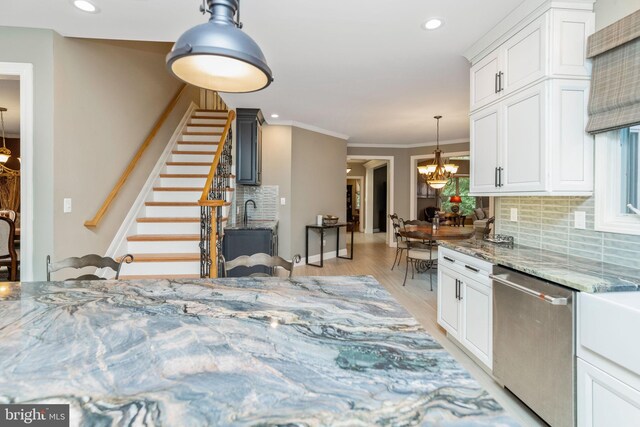 kitchen featuring decorative backsplash, light hardwood / wood-style floors, dishwasher, and light stone countertops