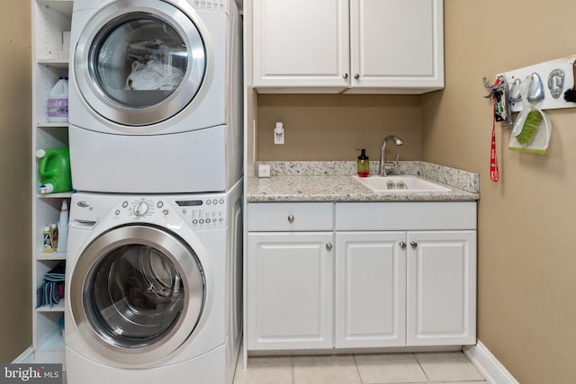 laundry room with sink, cabinets, stacked washer and clothes dryer, and light tile patterned floors