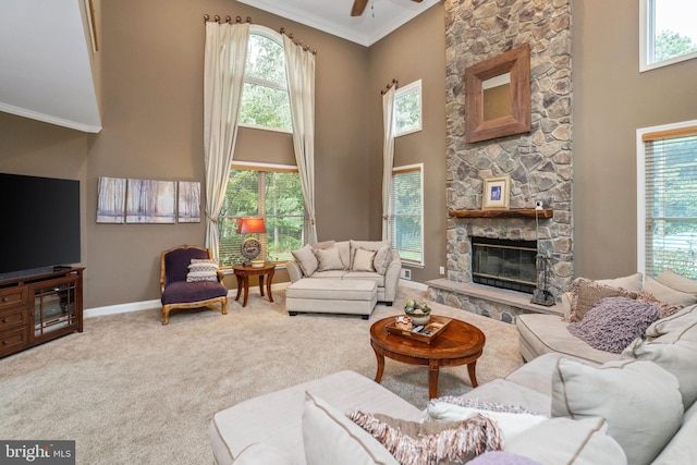 carpeted living room with plenty of natural light, ceiling fan, and a stone fireplace