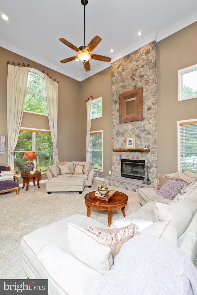 living room with carpet floors, a high ceiling, ceiling fan, and a fireplace