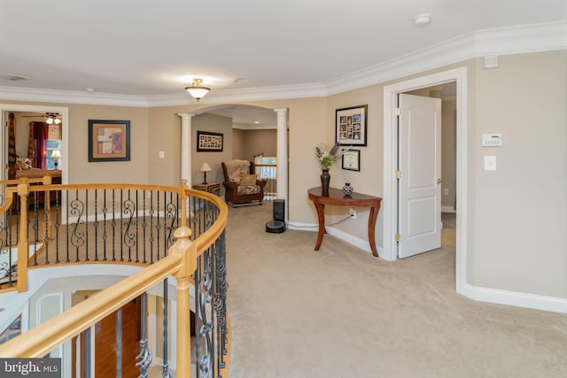 hallway featuring ornate columns, carpet, and crown molding