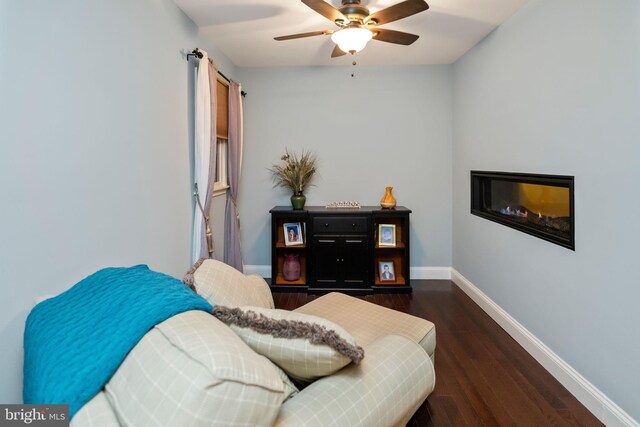 sitting room with ceiling fan and dark hardwood / wood-style flooring