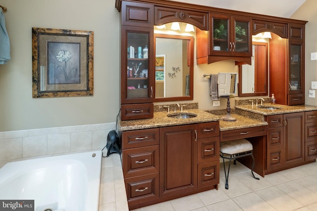 bathroom featuring tile patterned flooring, double vanity, and a tub to relax in