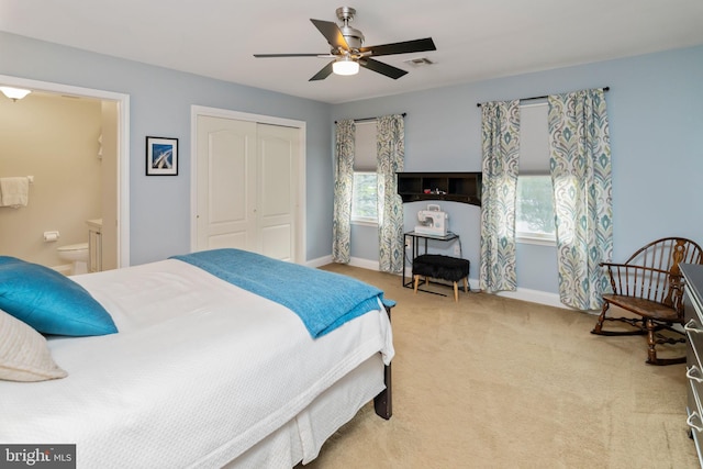 carpeted bedroom featuring ceiling fan, a closet, and ensuite bathroom