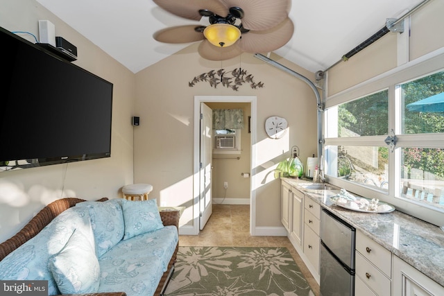 living room featuring ceiling fan, light tile patterned flooring, sink, and lofted ceiling