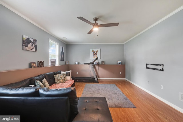 living room with wood-type flooring, crown molding, and ceiling fan