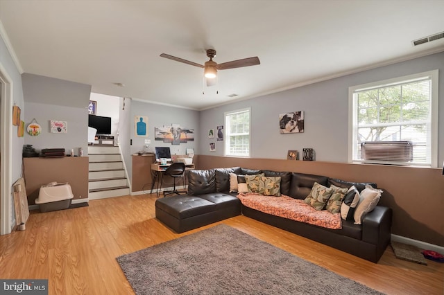 living room featuring a healthy amount of sunlight, ornamental molding, ceiling fan, and hardwood / wood-style flooring